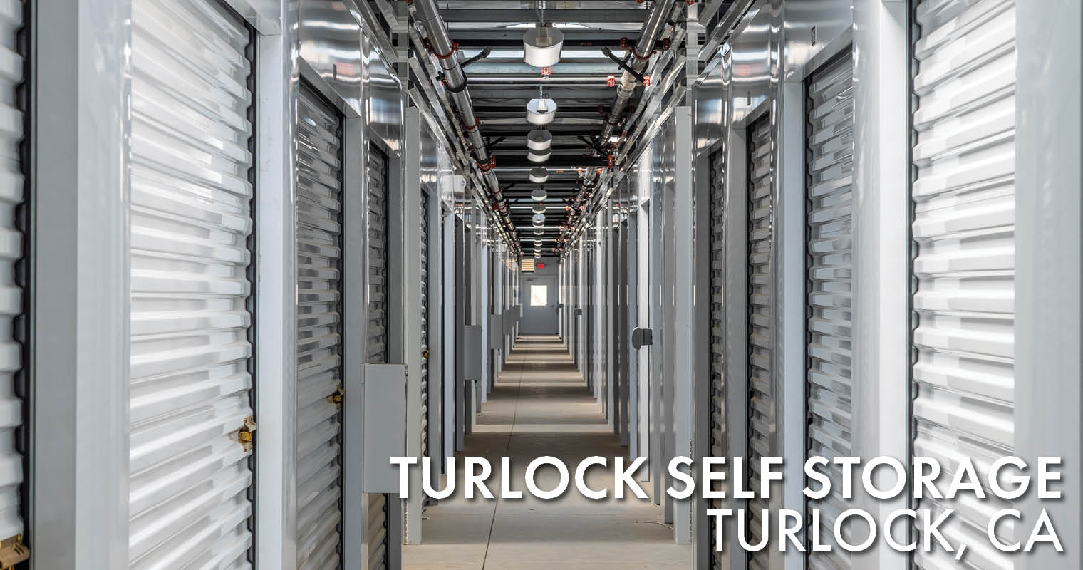 Photo of the interior corridor of the Turlock Self Storage construction project. It features new, clean, and white storage doors and panels.